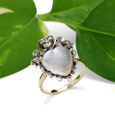 Georgian moonstone and diamond heart ring in yellow gold, displayed with green leaves