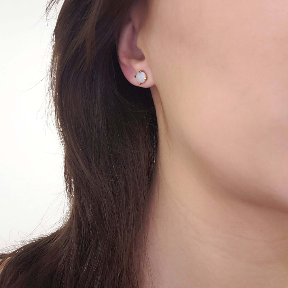 Opal stud earring in 14kt gold worn on ear