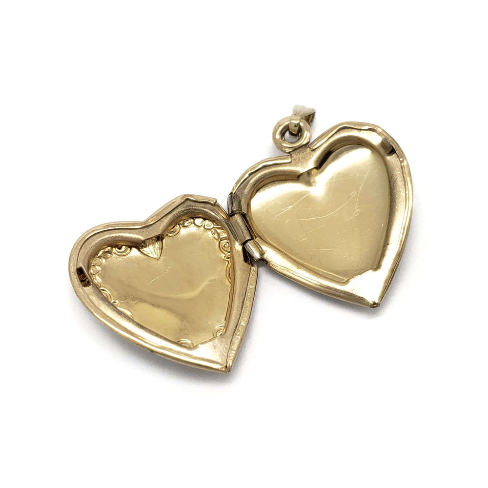 Open vintage 14kt yellow gold heart locket showing interior heart-shaped compartments