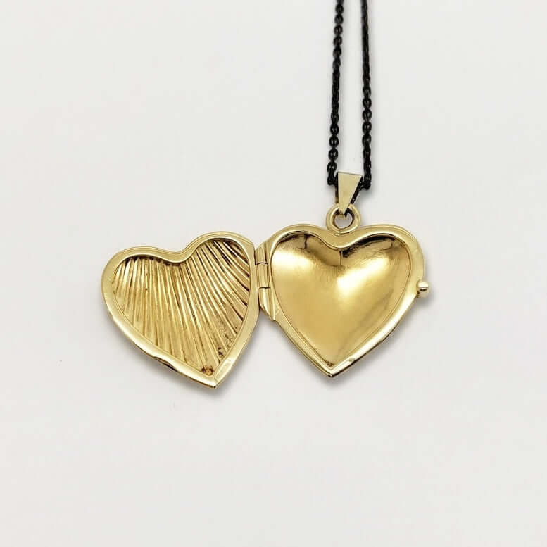Open 14kt yellow gold heart locket showing embossed and polished heart interior