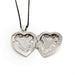 Open vintage sterling silver heart locket showing detailed interior engraving