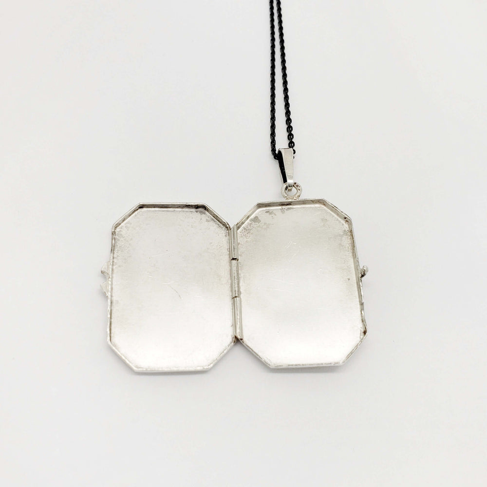 Open vintage sterling silver locket showing the two inner compartments