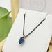 Oval London topaz pendant in 14kt rose gold on a black chain, displayed in a box