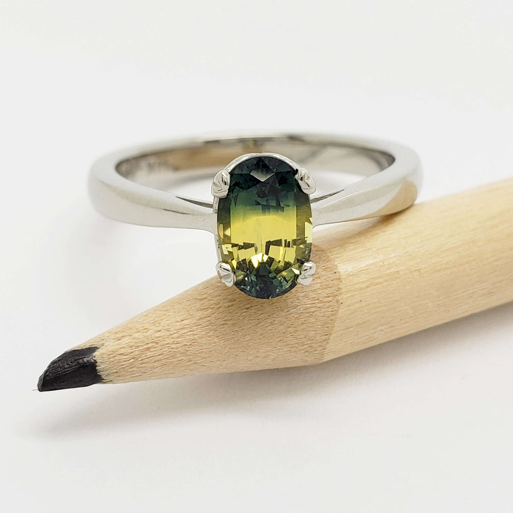 Oval bi-colour Australian sapphire ring in white gold displayed on a pencil
