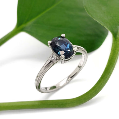 Oval blue-green Australian sapphire and diamond ring in white gold, styled with green leaf