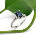 Oval blue-green Australian sapphire and diamond ring in white gold, styled with green leaf