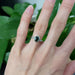 Oval green Australian sapphire and diamond ring in white gold, worn on a hand