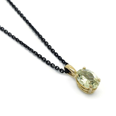 Oval green beryl pendant in 14kt yellow gold on a black chain, close-up view