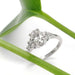 Oval lab diamond and accent diamond ring in white gold, styled with a green leaf