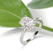 Oval lab diamond engagement ring in 14kt white gold, shown with green leaves