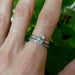 Oval lab diamond engagement ring in white gold stacked with matching band on hand