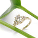 Oval lab diamond engagement ring in yellow gold, styled with green leaf