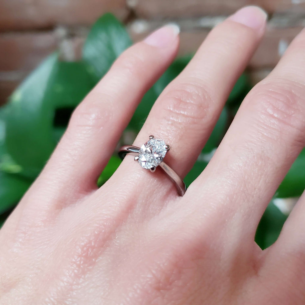 Oval lab diamond solitaire ring in 14kt white gold on hand