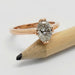 Oval lab-grown diamond solitaire ring in rose gold, shown resting on a pencil