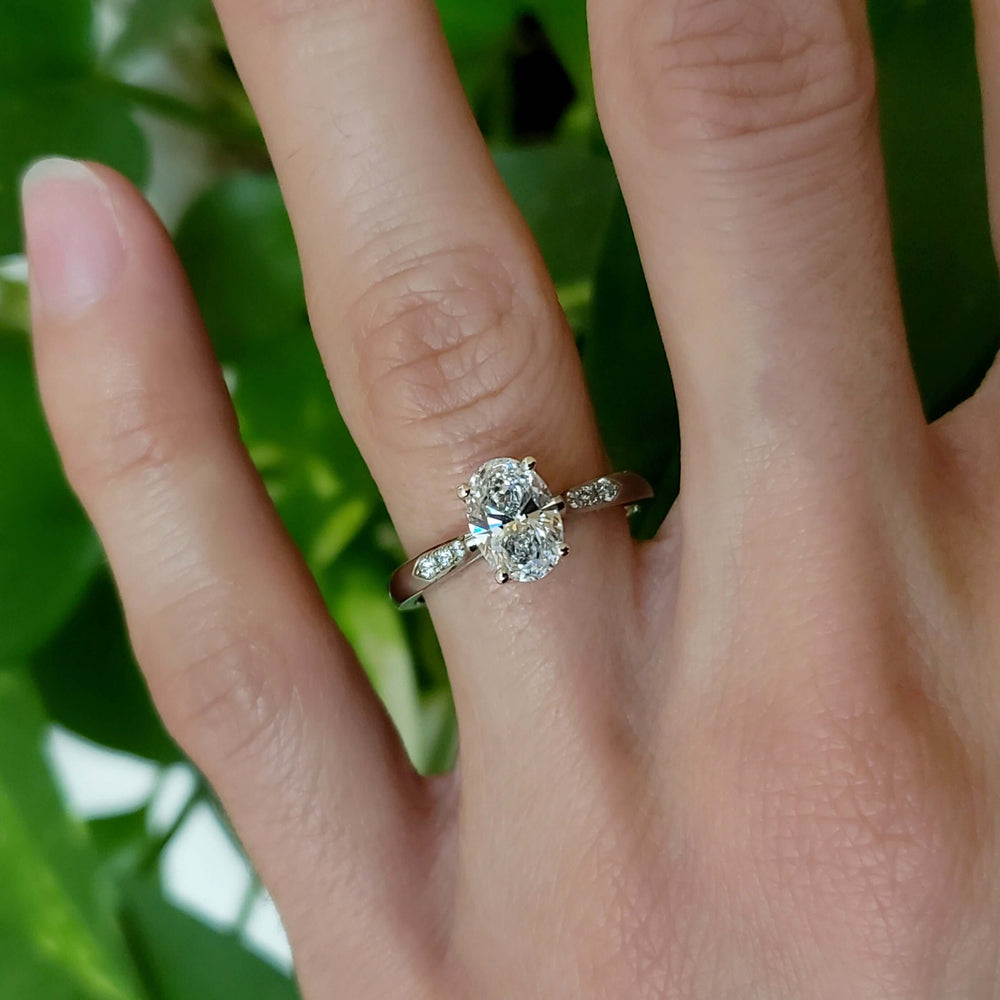 Oval lab diamond white gold engagement ring with pave band shown on hand