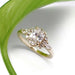 Oval lab grown diamond cluster ring in 14kt yellow gold, displayed on white with green leaf