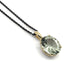 Oval prasiolite pendant in 14kt yellow gold on black chain, close-up on white background
