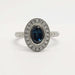 Front view of oval teal sapphire and diamond halo engagement ring in white gold