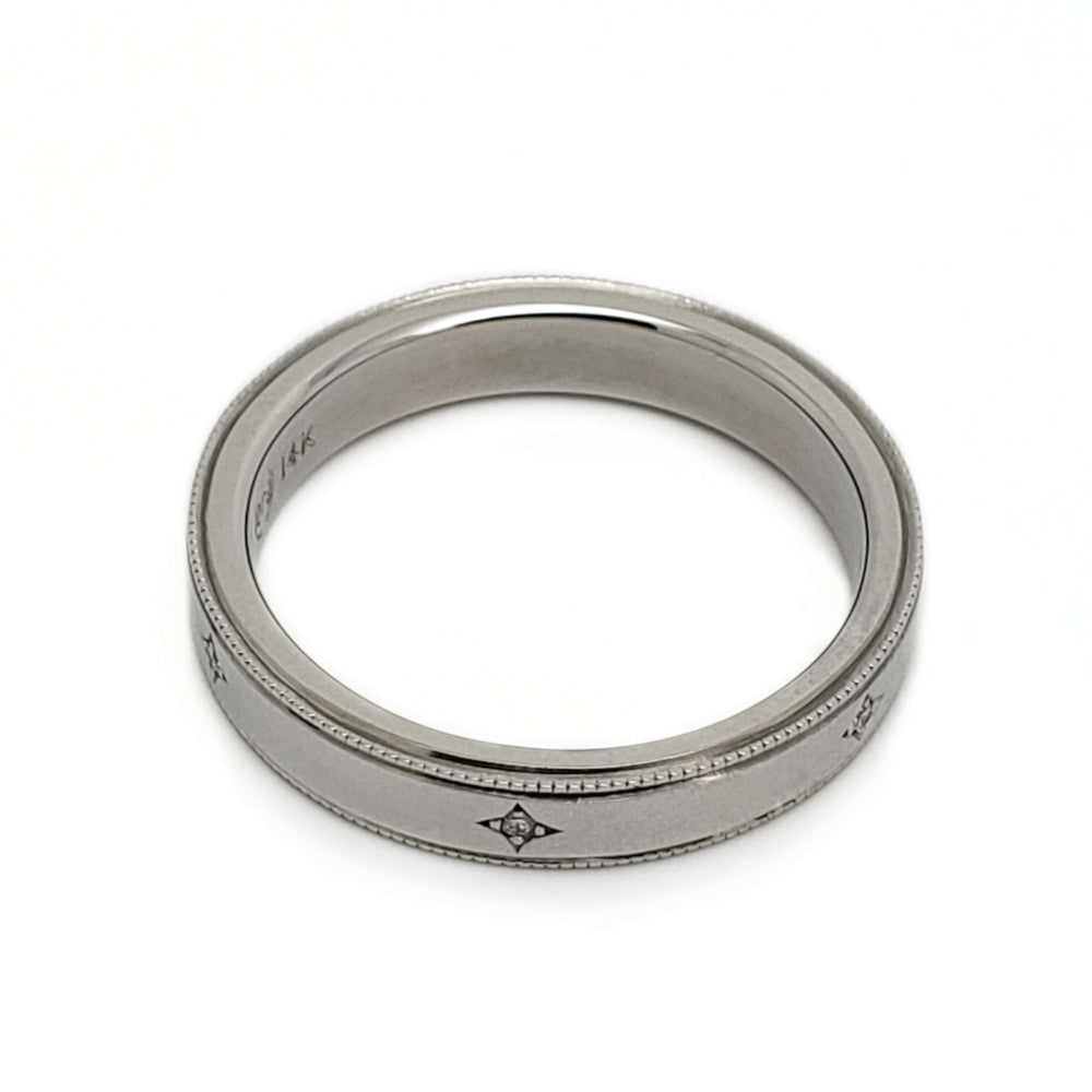 Overhead view of 14k white gold wedding ring with diamond accents and millgrain edge
