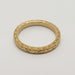 Overhead view of 14kt yellow gold wedding ring with detailed Salal engraving and millgrain edge