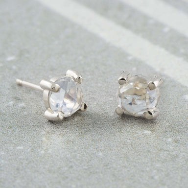 Pair of rose cut moonstone stud earrings in 14kt white gold on stone background