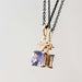 Two yellow gold sapphire and lab diamond pendants on black chains, shown together