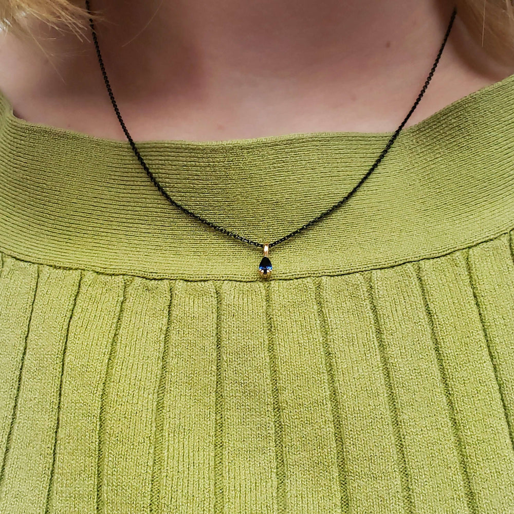 Pear blue sapphire pendant necklace in yellow gold, worn on model