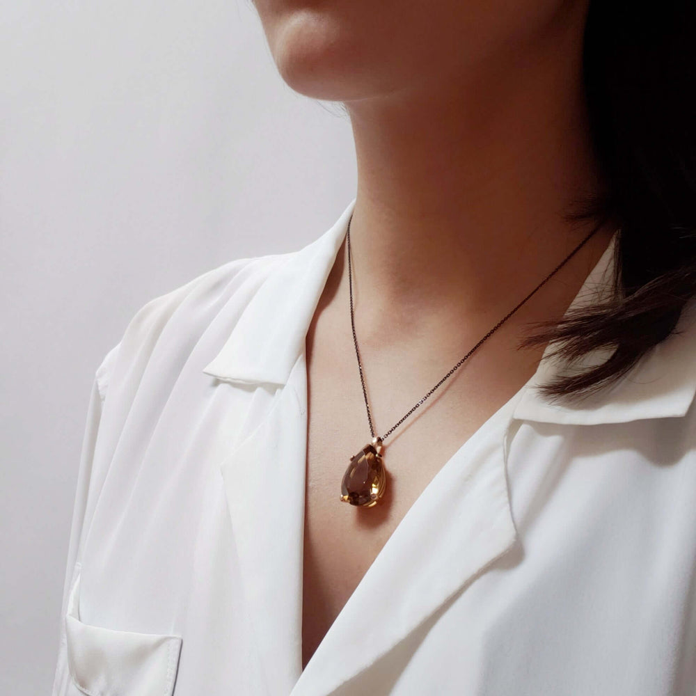 Pear citrine pendant in 14kt yellow gold worn on a black chain, shown on model