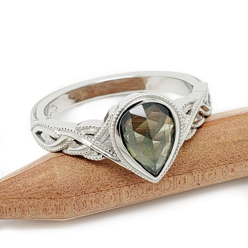 Pear rose cut green sapphire engagement ring in 14kt white gold on wood background