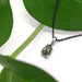 Pear rose cut green sapphire pendant in 14k white gold on black chain with green leaves