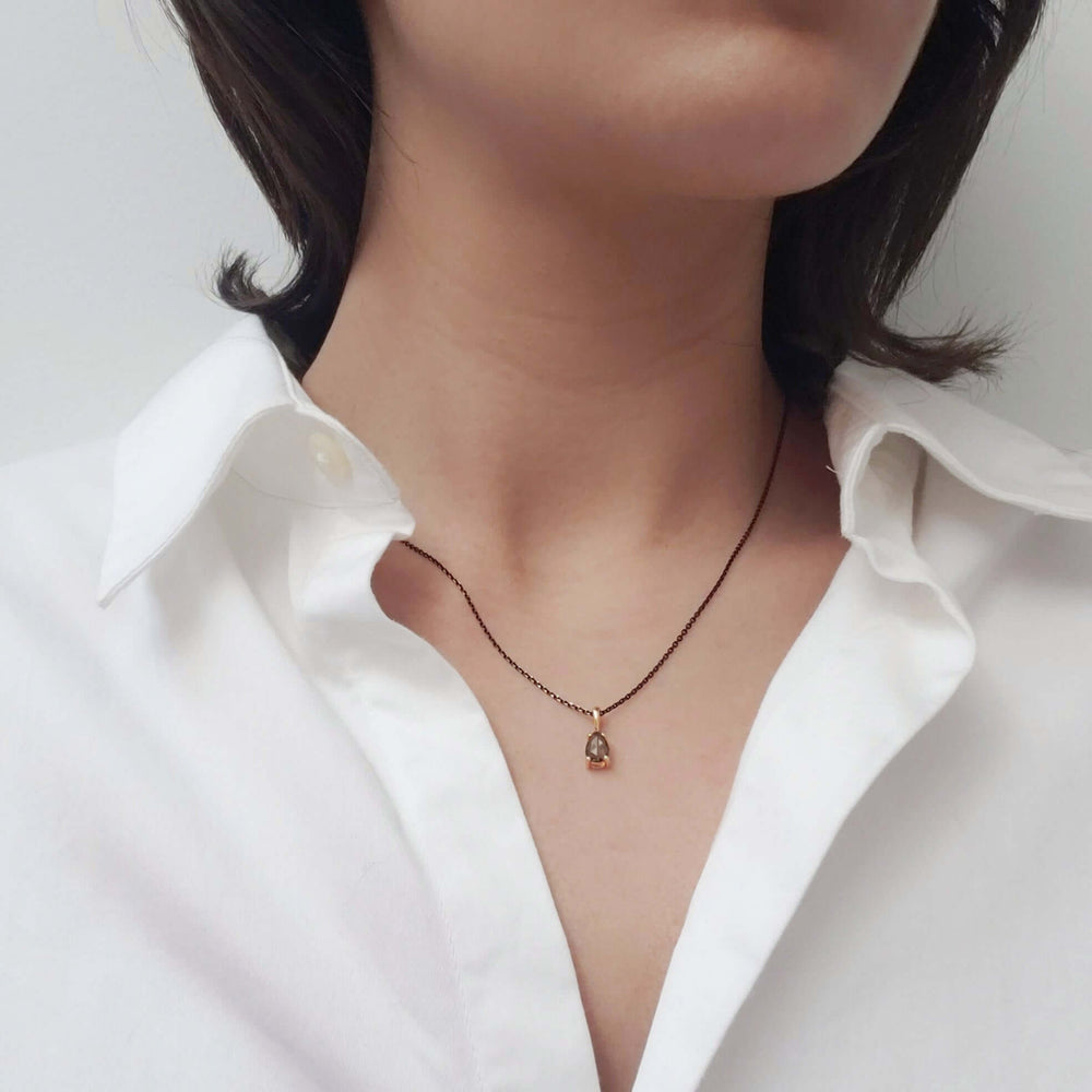 Pear rose cut green sapphire pendant in 14k yellow gold on black chain worn on neck