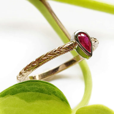 Pear ruby engagement ring in yellow and white gold with engraved wheat pattern band