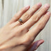 Petite Moraine 14kt yellow gold diamond engagement ring stacked with a gold wedding band on hand
