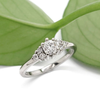 Petite Zira lab diamond ring in 14kt white gold, displayed with green leaves
