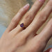 Pink sapphire yellow gold engagement ring shown on hand