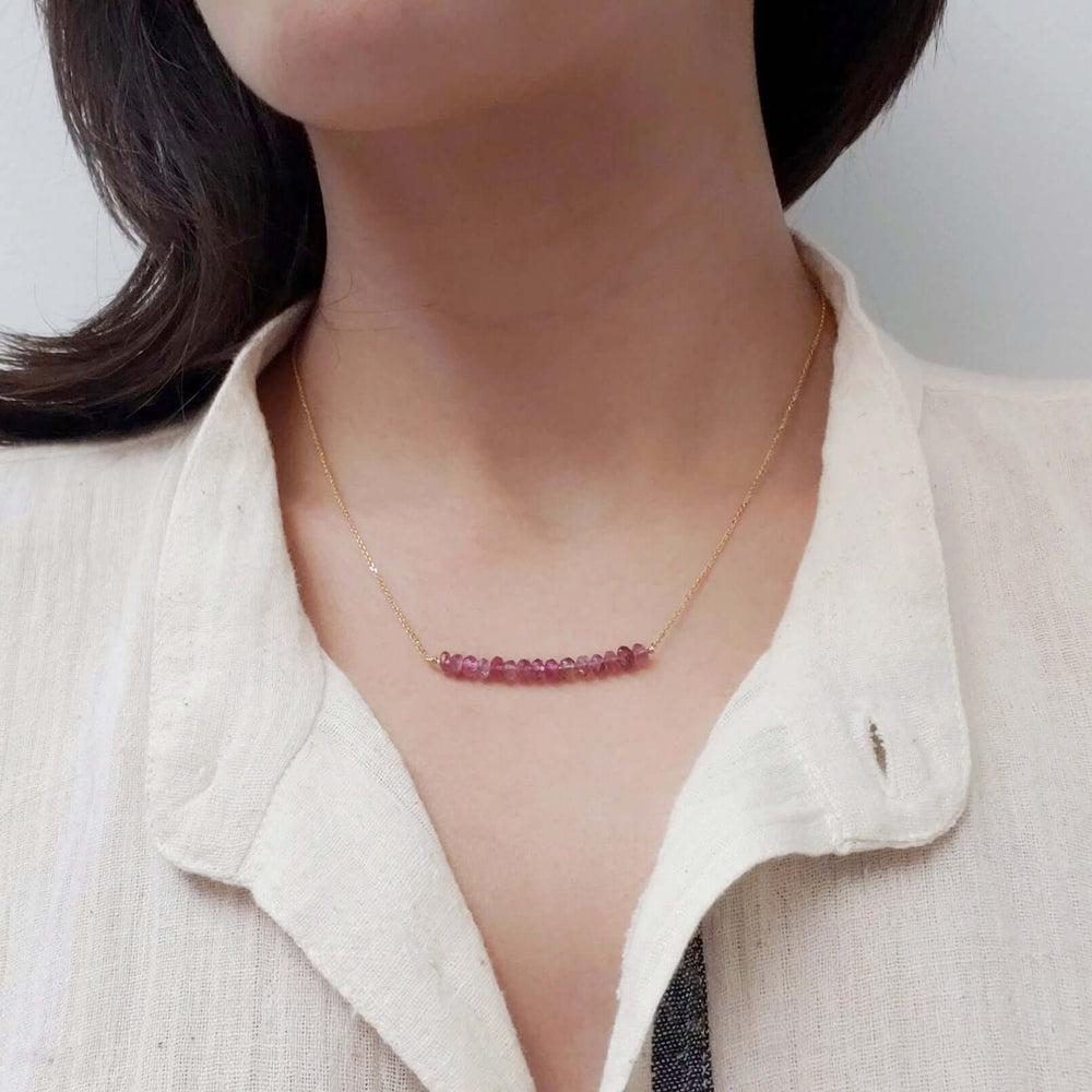 Pink tourmaline bead bar necklace in 14kt yellow gold worn on a model
