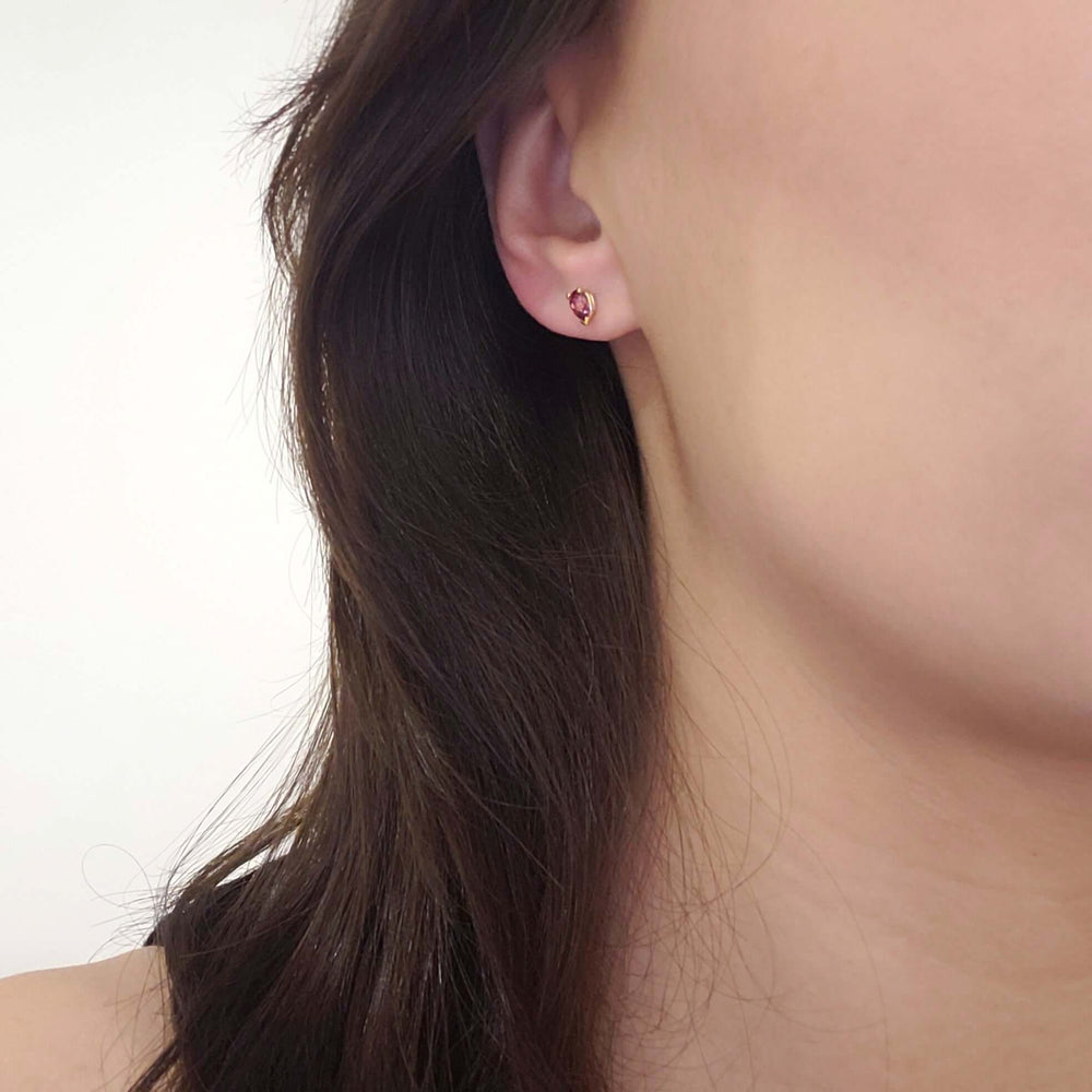 Pear cut pink tourmaline stud earring in 14kt yellow gold worn on ear