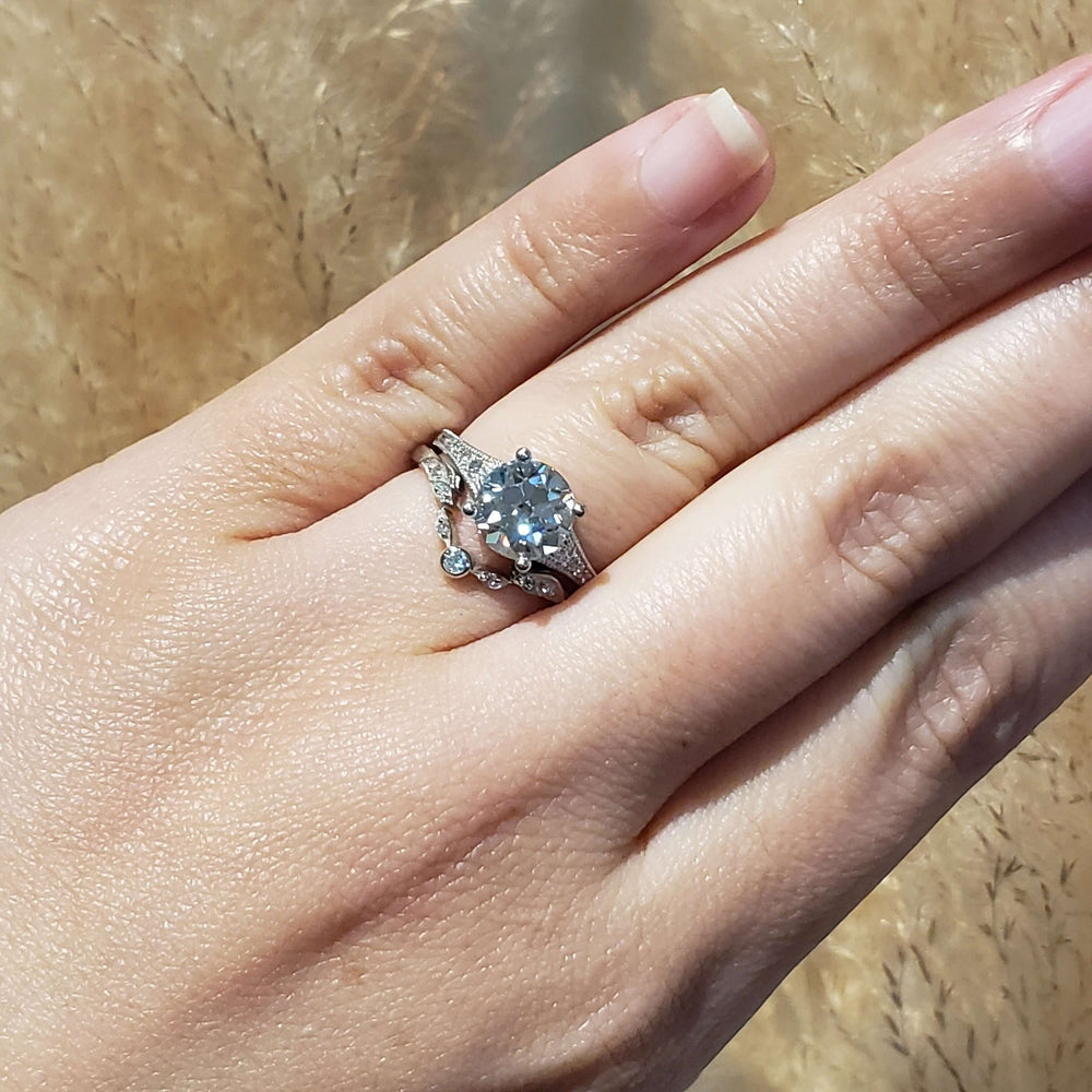Platinum lab diamond engagement ring stacked with a diamond wedding band on hand