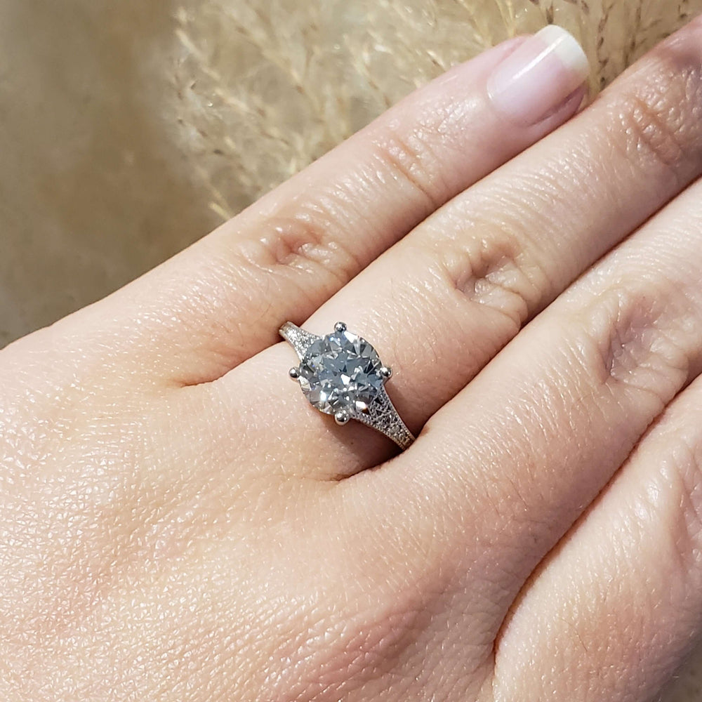 Platinum lab diamond engagement ring worn on hand, showing intricate band details