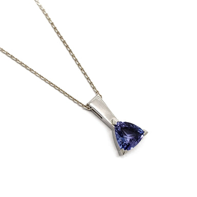 Platinum pendant with trilliant cut blue tanzanite on a fine chain, shown on white background