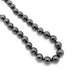 Close-up of polished hematite bead necklace strung on deep blue thread