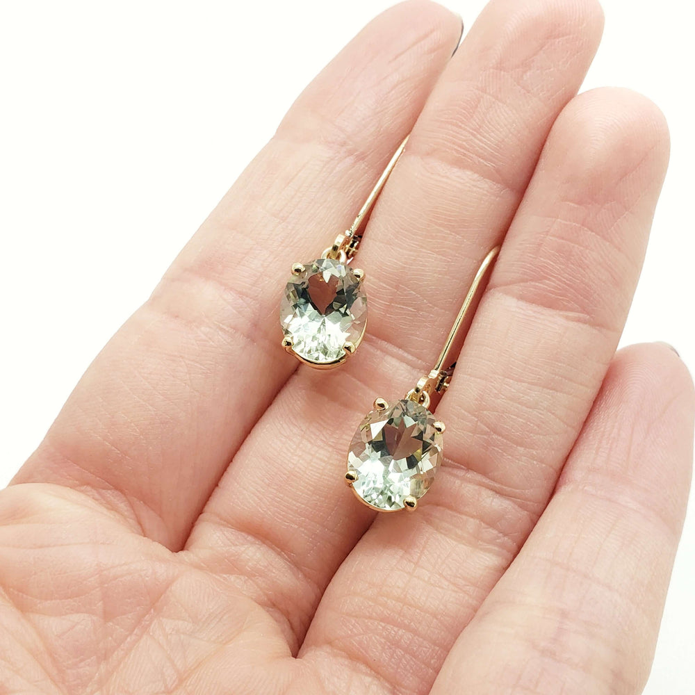 Prasiolite dangle earrings in 14kt yellow gold shown resting on a hand