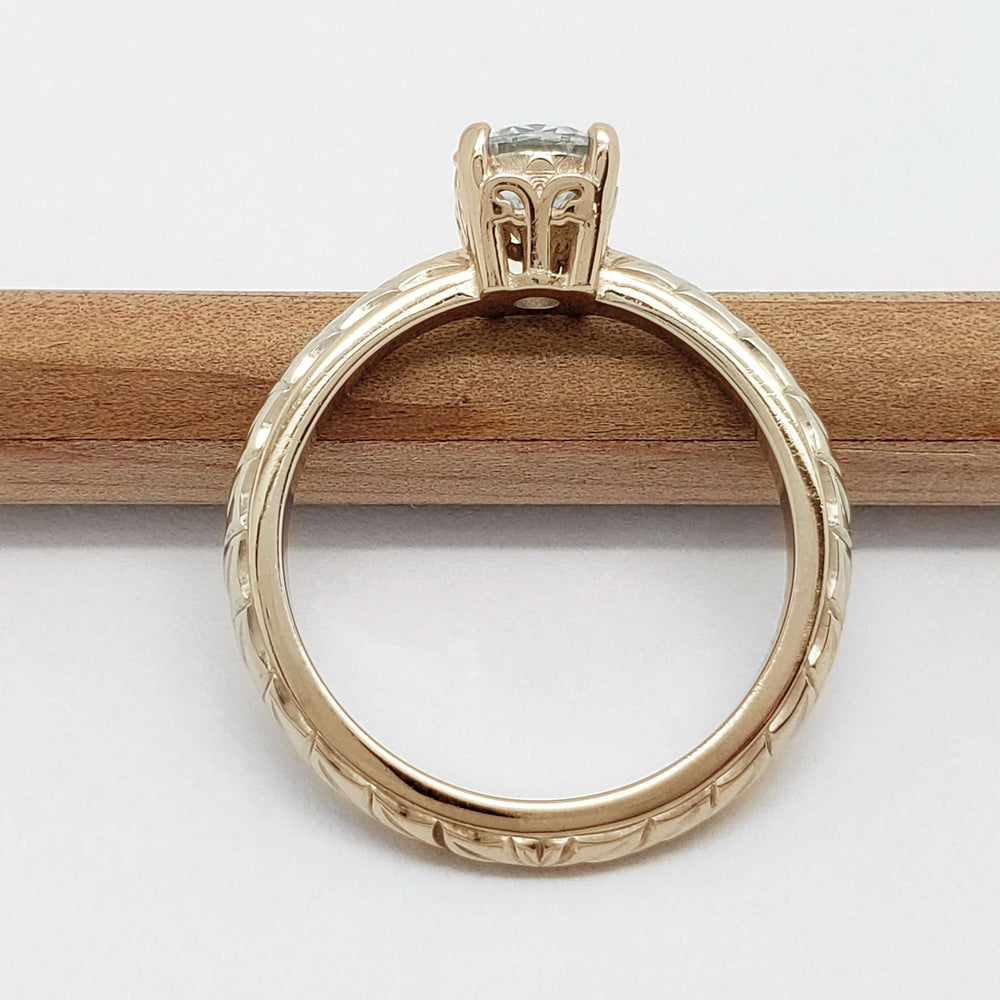 Profile of 14k yellow gold engagement ring with moissanite and wheat engraving