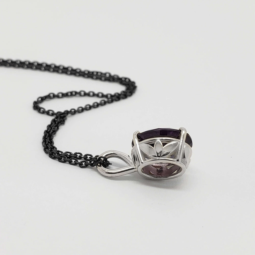 Side view of 14kt white gold pendant with oval lab grown purple sapphire and black chain
