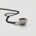 Side view of 14kt white gold pendant with oval lab grown purple sapphire and black chain
