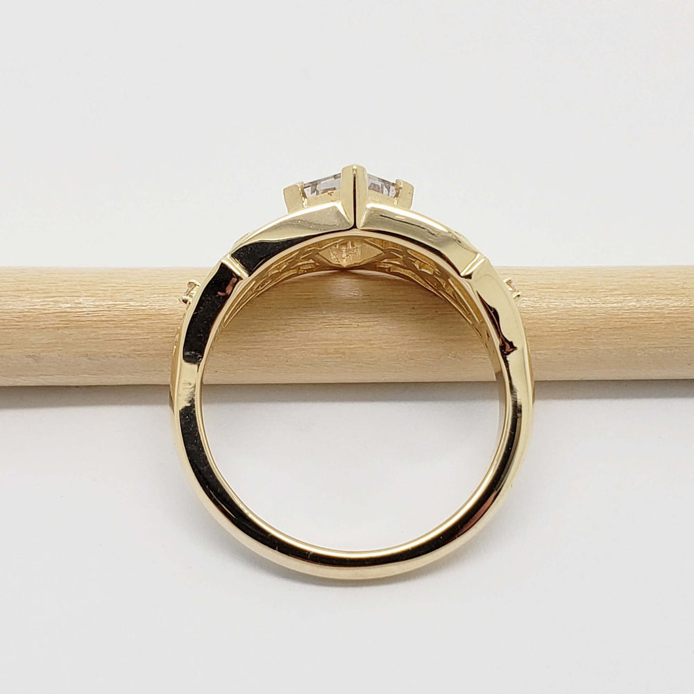 Profile view of 14kt yellow gold ring with shield cut sapphire and filigree, on a pencil
