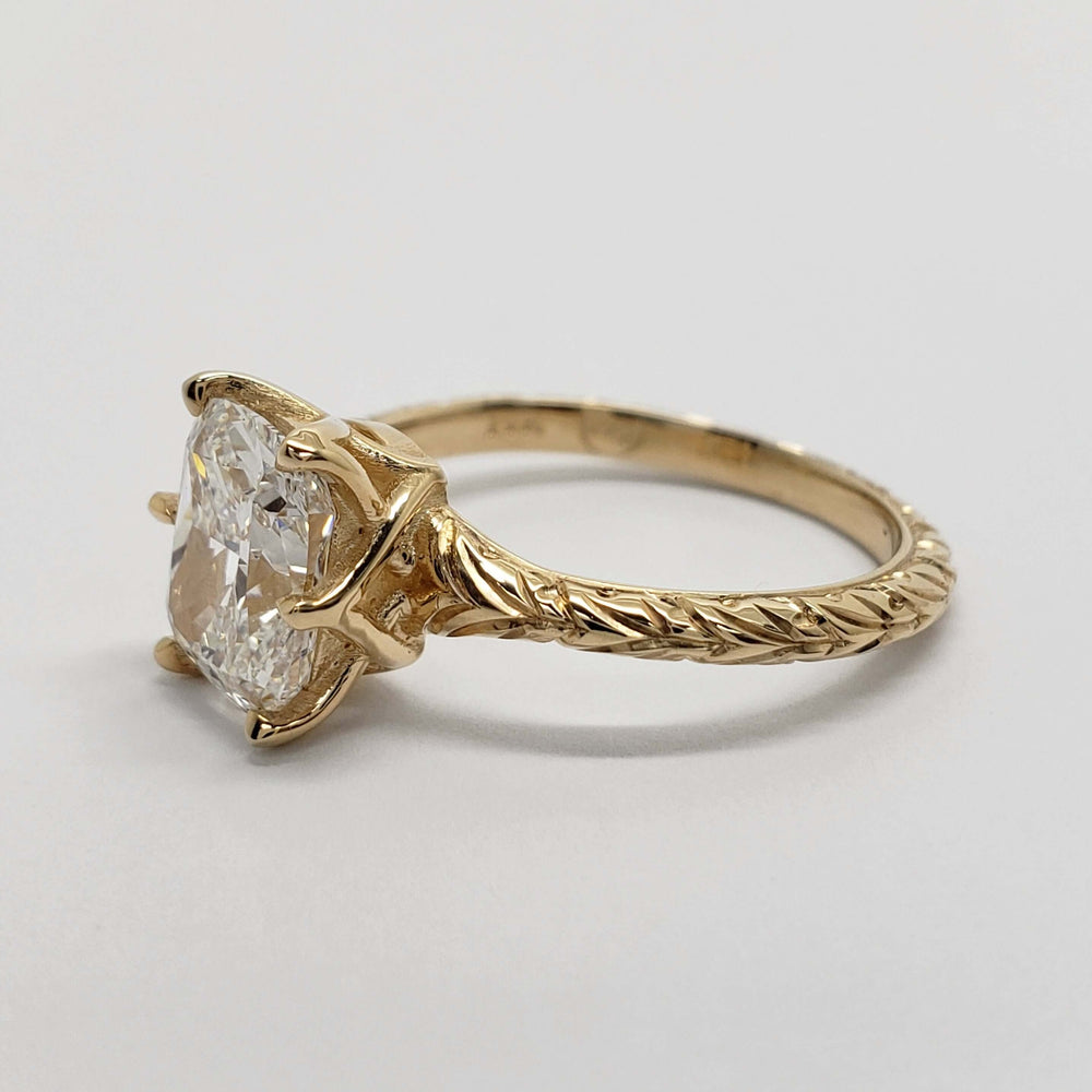 Profile of engraved 14kt yellow gold engagement ring with cushion cut lab diamond