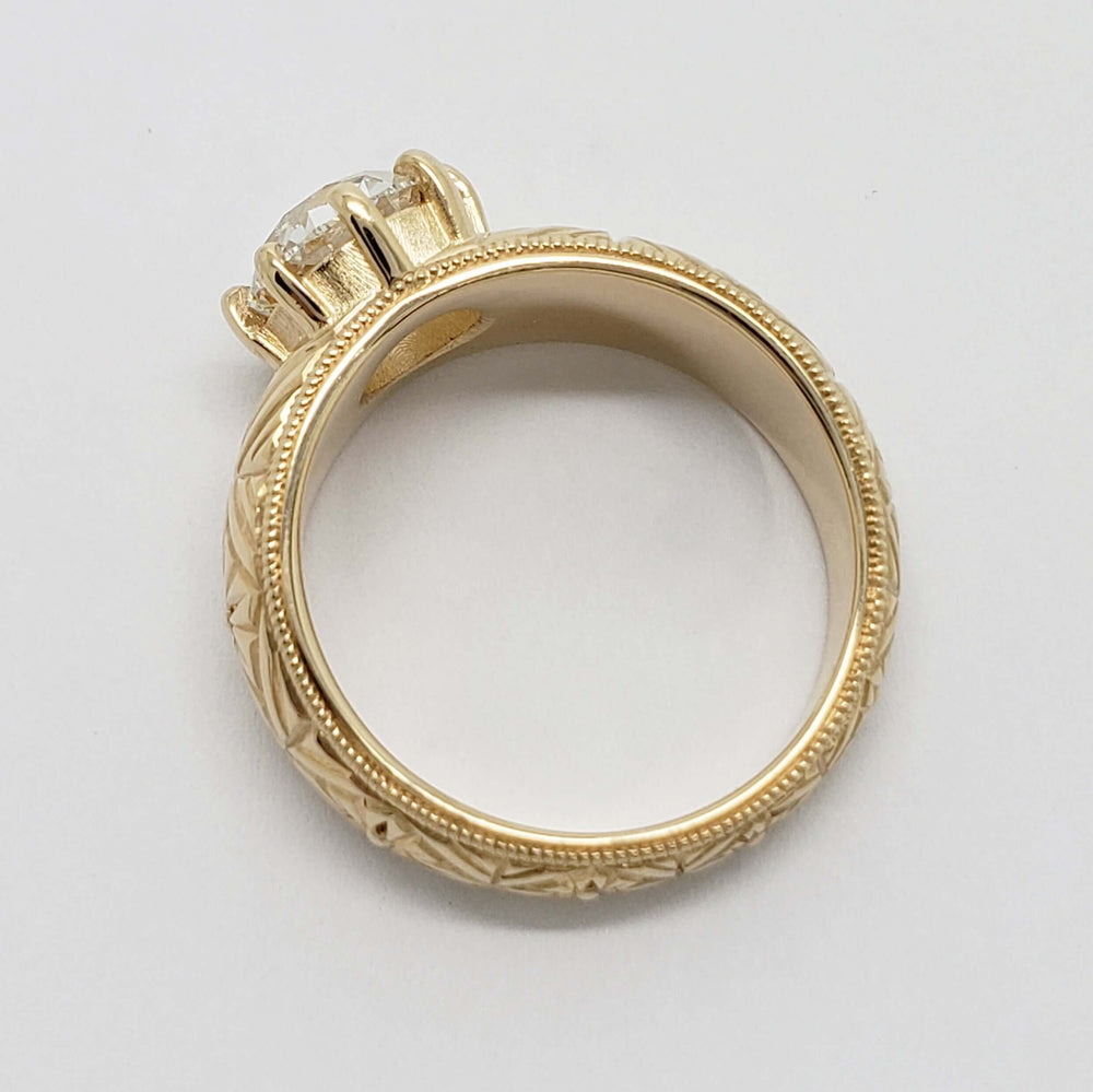 Profile of engraved yellow gold ring with millgrain edge and lab diamond setting