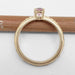 Profile view of yellow gold pink sapphire ring with diamonds, on pencil