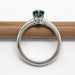 Profile view of white gold solitaire ring with blue Montana sapphire on a pencil